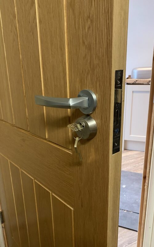 Oak internal door with chrome handle and lock.