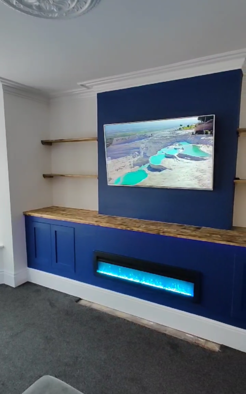 Blue media wall including shelves, units and fireplace.