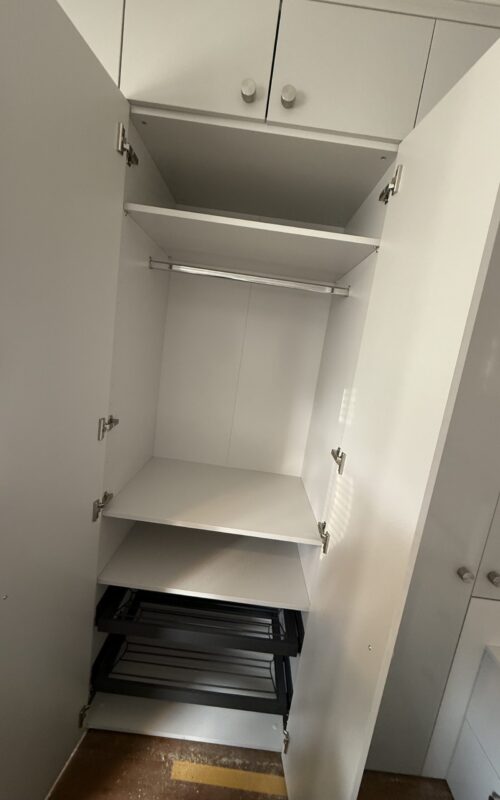 Built in wardrobe including hanging rails, shelves and drawers.