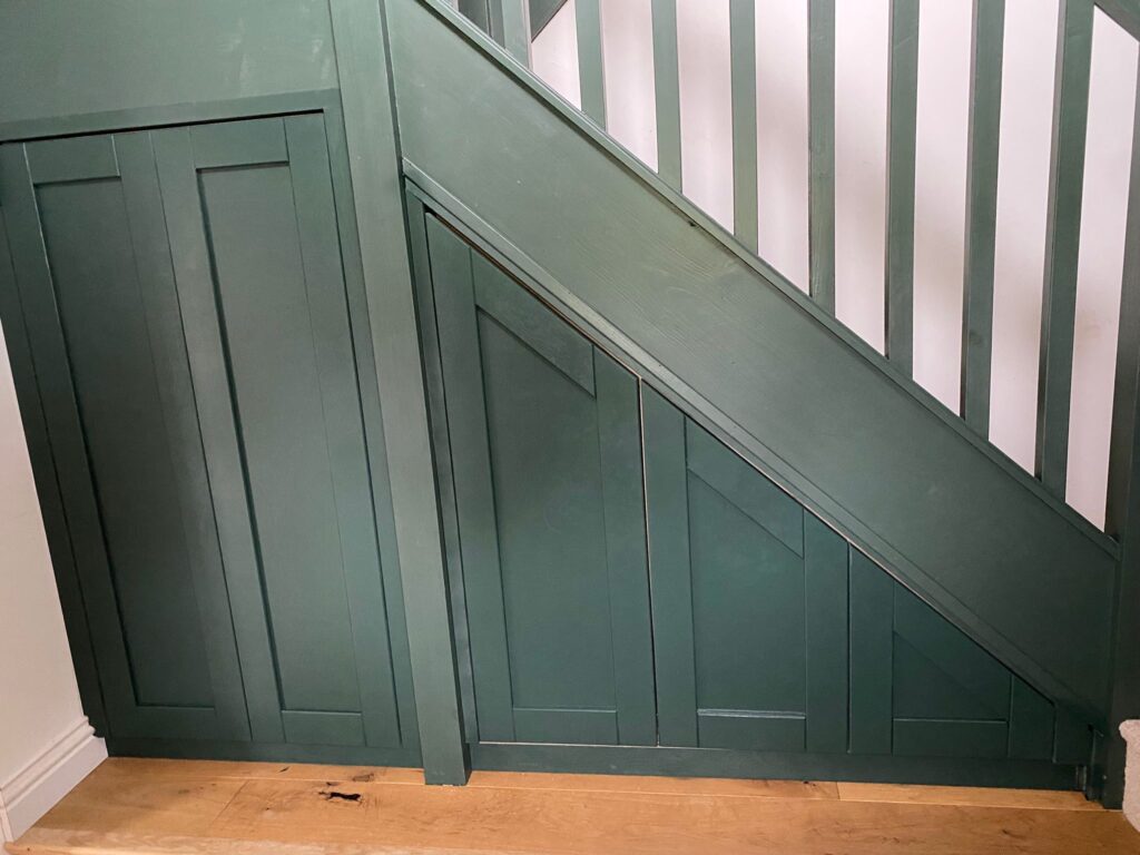 Custom built under stairs storage sprayed in green to match current staircase - Revitalise Interiors